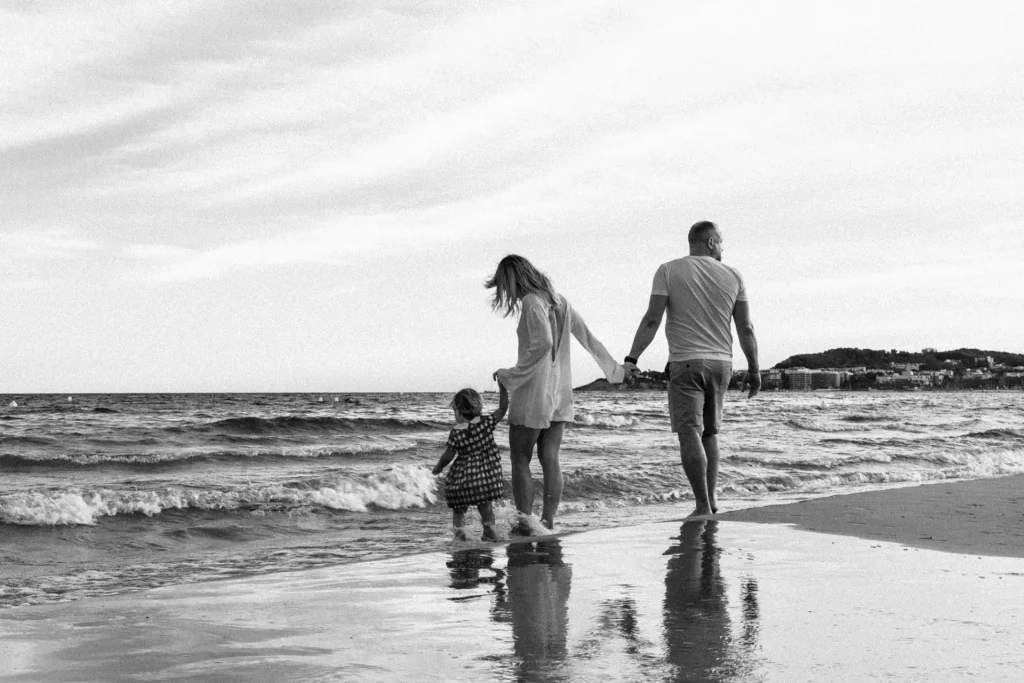 Familia paseando por la orilla del mar